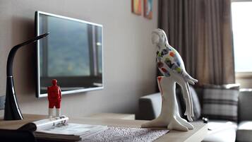 Uma mesa com uma televisão, uma estatueta e um objeto decorativo.