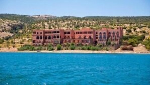 A coastal building with multiple balconies overlooking the sea. - Hotel Chems du Lac (Bine el Ouidane)