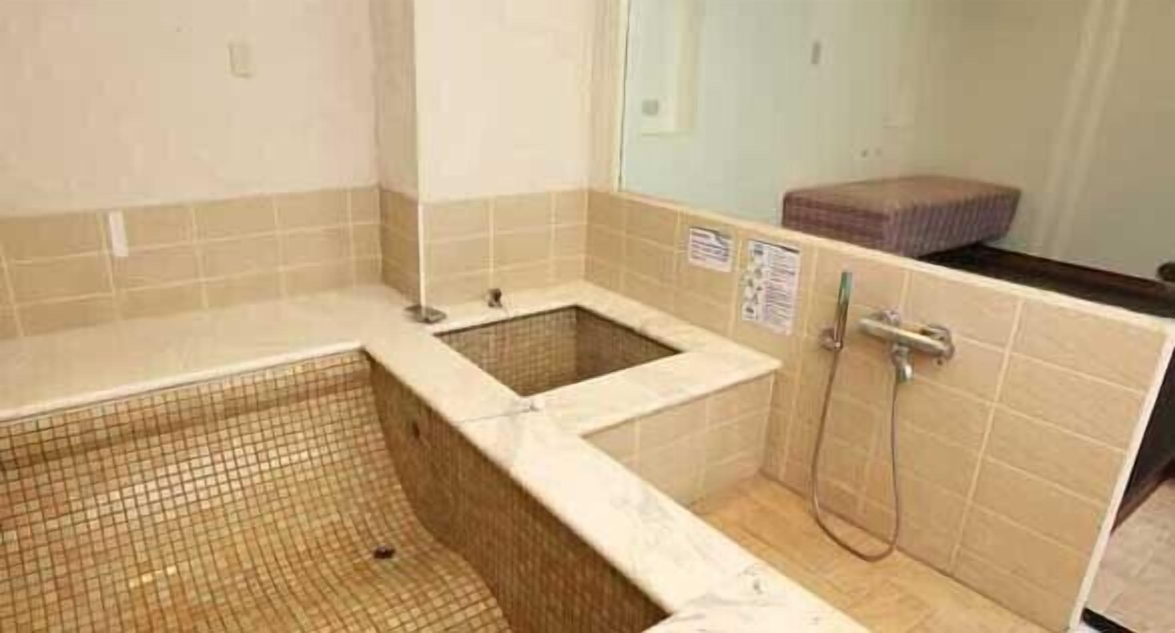 A small, tiled bathroom with a shower, a toilet, and a sink.
