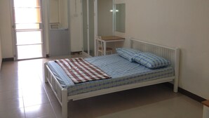 Een slaapkamer met een bed, een bureau en een kledingkast.