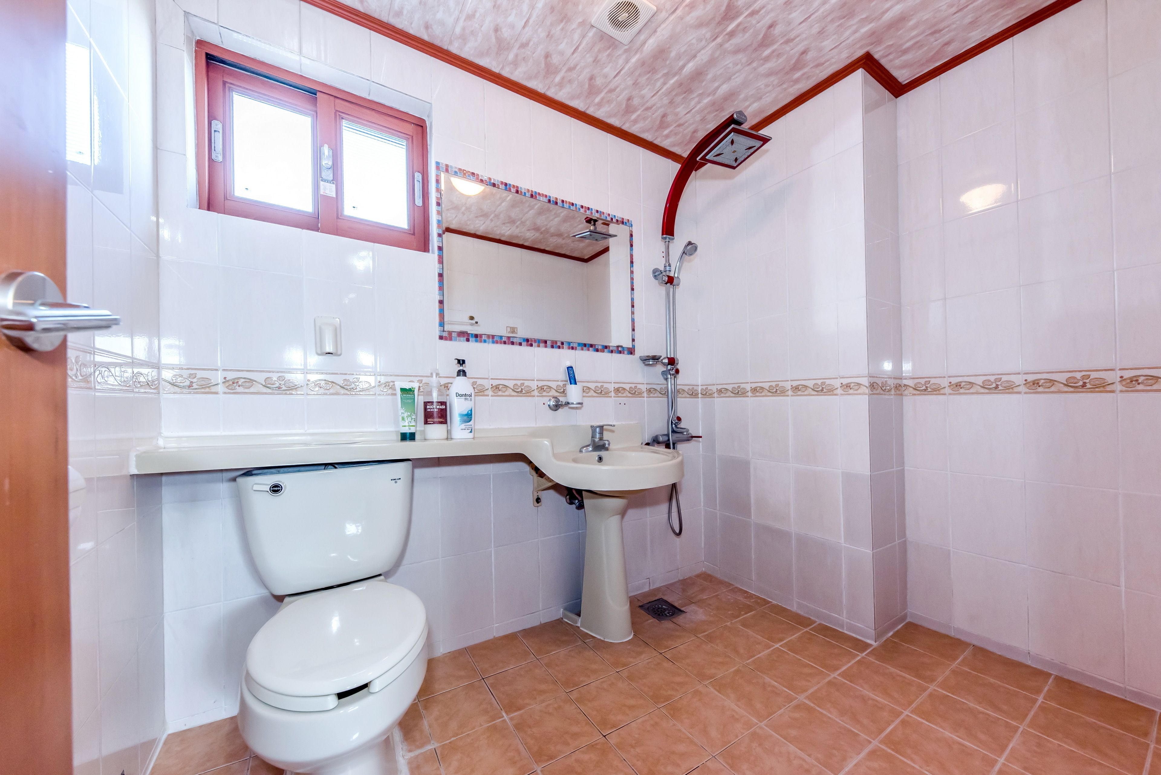 A bathroom with a toilet, sink, and shower.