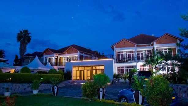A large, multi-story hotel with a well-lit entrance and a landscaped garden. - Quiet Haven Hotel (Kigali)
