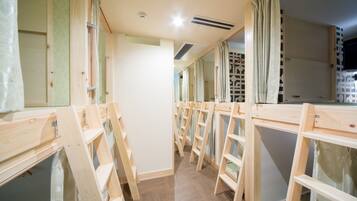 A corridor with wooden ladders and curtains, leading to a room with a television.