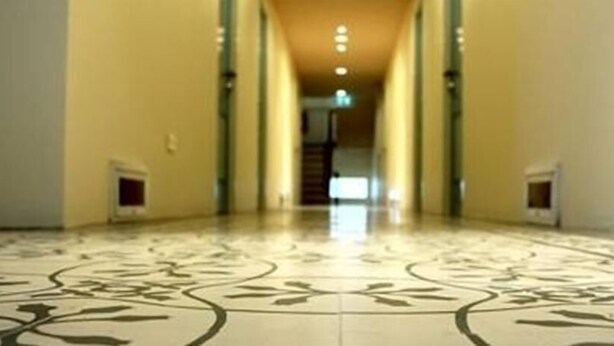 A hallway with a patterned floor and a staircase in the distance. - Roof View Place (Bangkok)