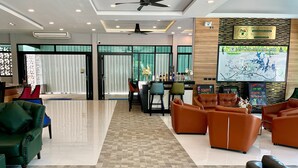A modern hotel lobby with a reception desk, seating area, and a large map on the wall.
