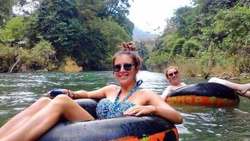 Two people floating on a river in an inflatable tube.
