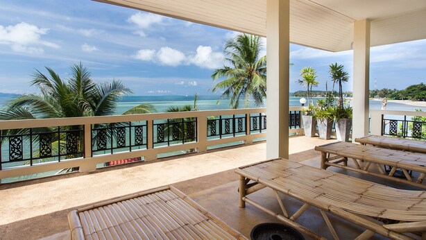 Un espace extérieur abrité, aménagé avec du mobilier en bambou et offrant une vue sur l’océan.