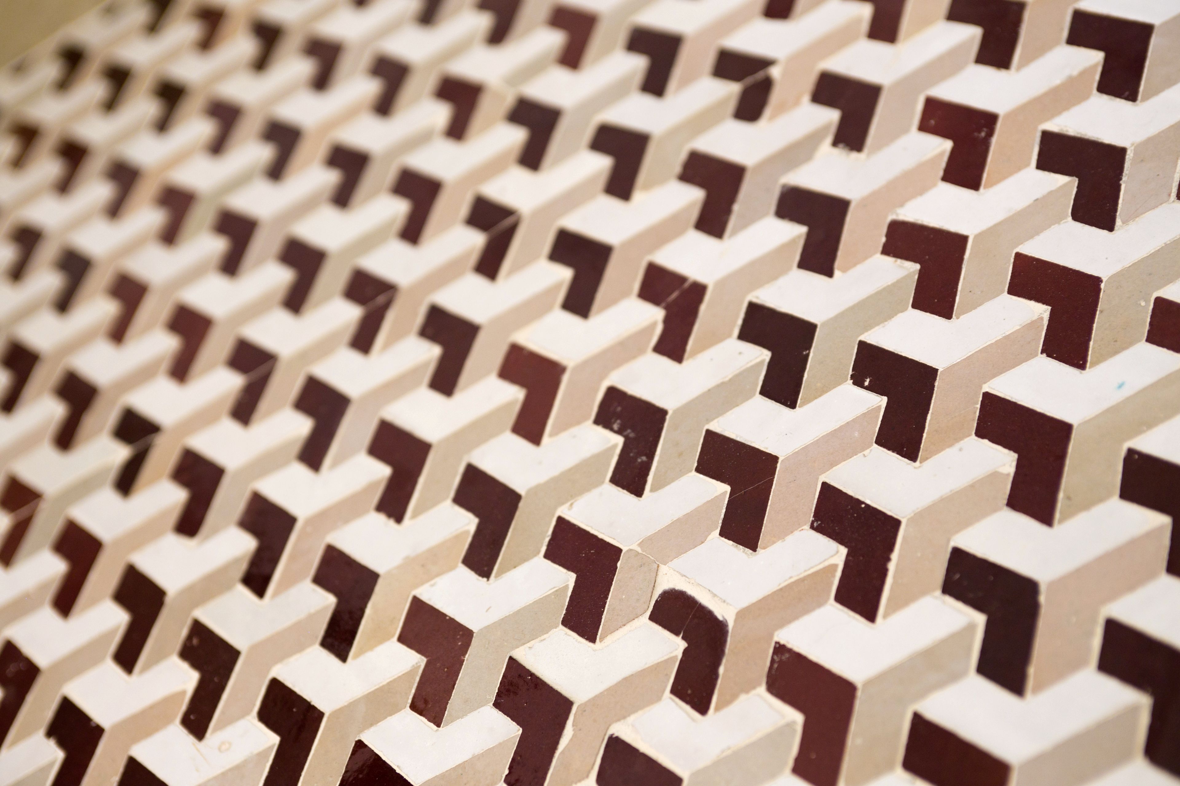 A close-up of a patterned wall with a repeating geometric design.