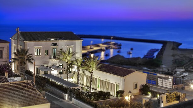 A model of a coastal building with a terrace, palm trees, and a view of the sea. - Zafran Boutique Hotel (Scicli)