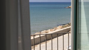 A view of the sea through a window with a stone wall and railing in the foreground. - Zafran Boutique Hotel (Scicli)
