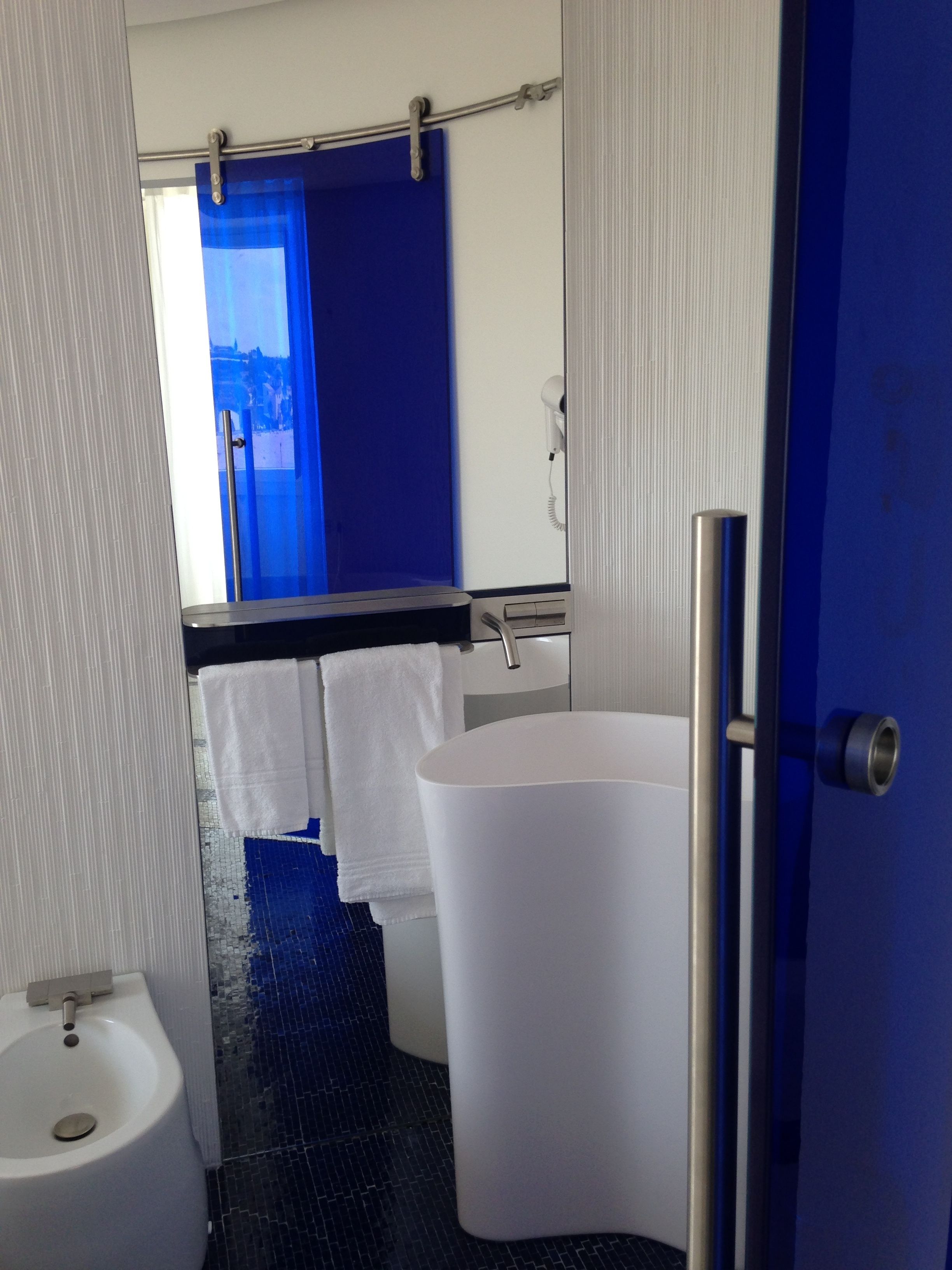 A modern bathroom with a white sink, a large bathtub, and a mirror above the sink.