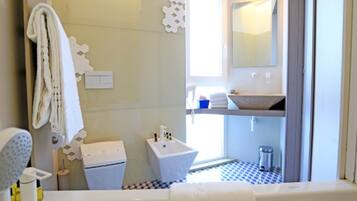 A bathroom with a bathtub, a sink, and a toilet. There is a towel rack and a mirror on the wall.