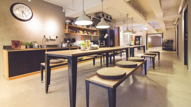 A modern kitchen with a central island, pendant lighting, and a clock on the wall. - Ahiruyah Guest House in Kaohsiung - Hostel (Kaohsiung)