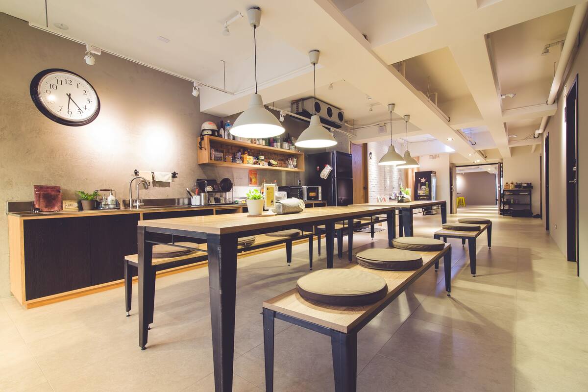 A modern kitchen with a central island, pendant lighting, and a clock on the wall.