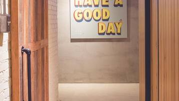 A hallway with a motivational sign saying "HAVE A GOOD DAY" and wooden walls.