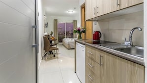 Une cuisine moderne avec des meubles en bois, un évier en acier inoxydable et un lave-vaisselle compact.
