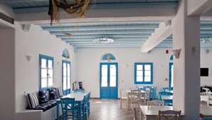 A spacious dining area with blue and white decor, featuring a high ceiling and a central arched doorway. - Viva Mare Hotel (Pylos-Nestoras)