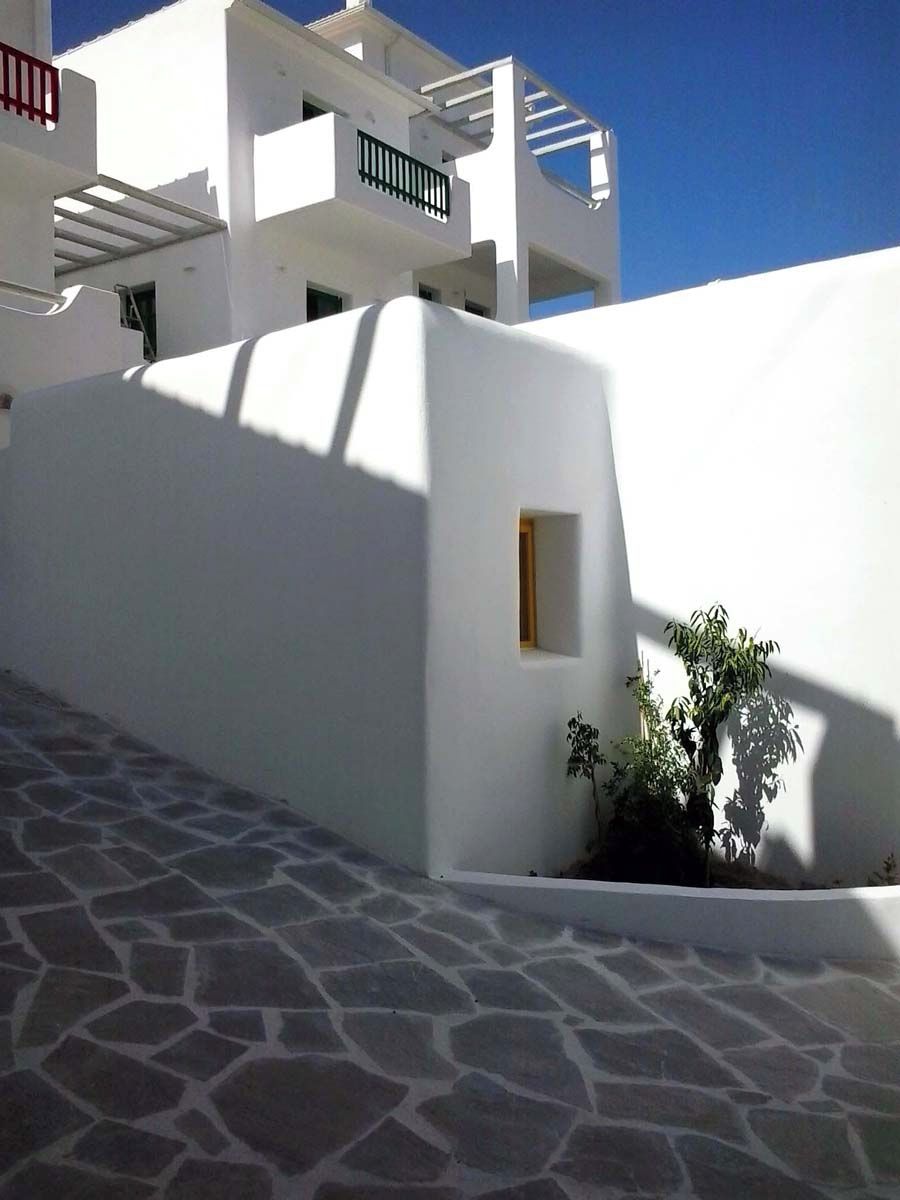 A white building with a stone-paved entrance and a small window.