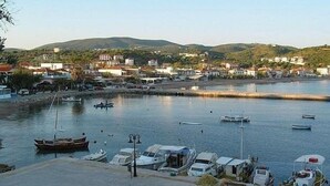 A marina with boats docked, a waterfront promenade, and buildings in the background. - Viva Mare Hotel (Pylos-Nestoras)