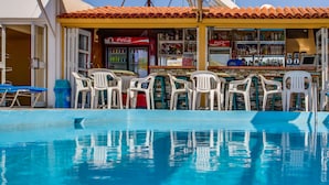 A poolside bar with white plastic chairs and a Coca-Cola refrigerator. - Paul Marie Hotel Apartments (Ayia Napa)