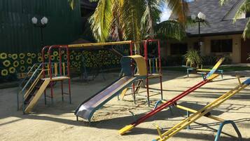 Kids can play on the playground with slides and swings.