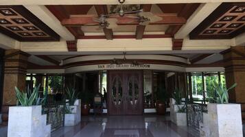A grand entrance with a ceiling fan, a sign reading "SANDUGO GRAND BALLROOM", and a tiled floor.