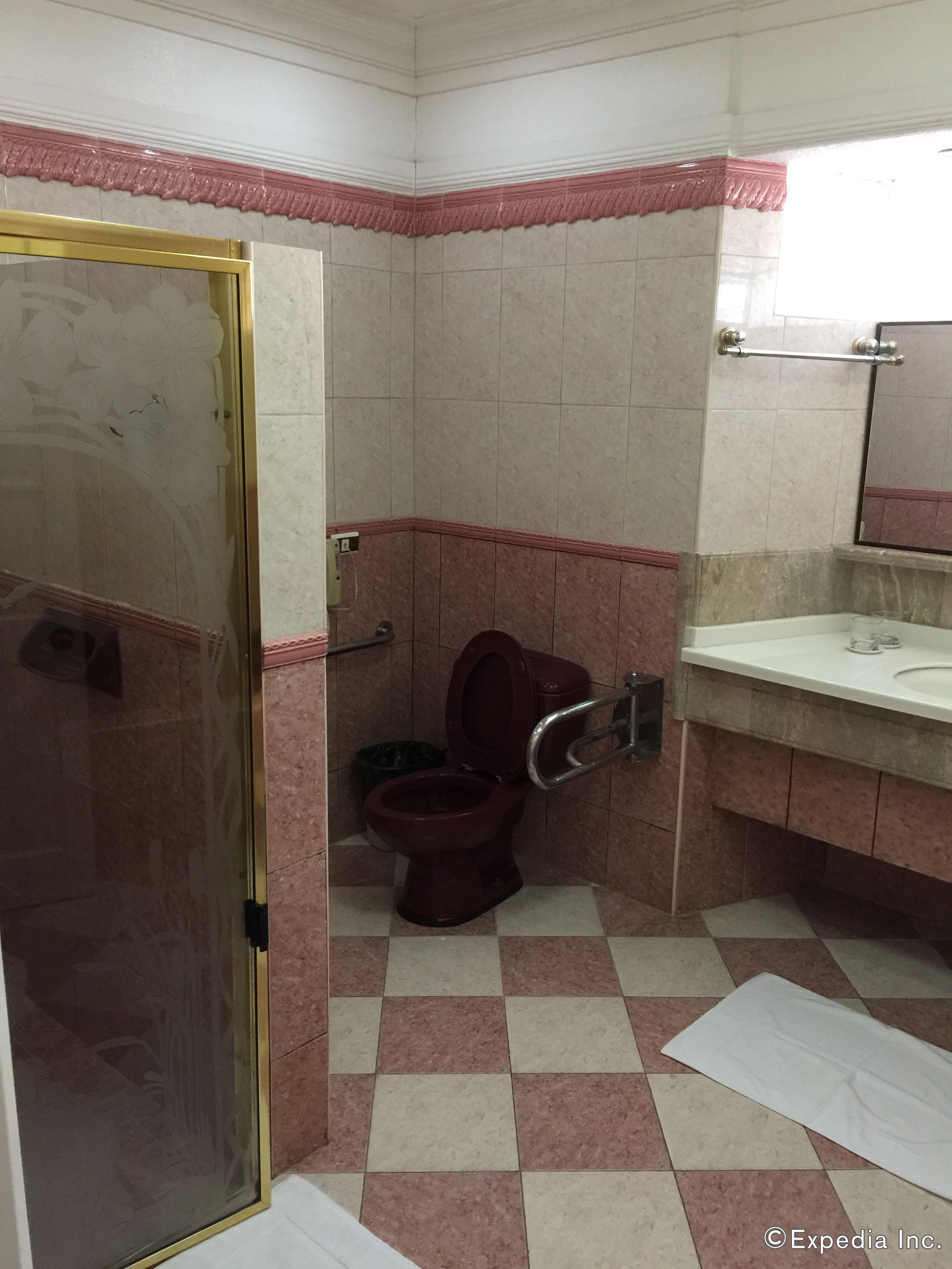 Une salle de bain comprenant des toilettes, un lavabo et un espace douche.