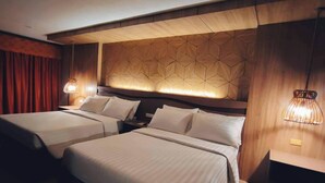 A hotel room with two beds, a geometric patterned headboard, and bedside lamps. - Bohol Tropics Resort (Tagbilaran)