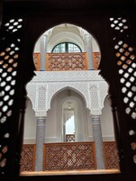 Uma arcada arquitetônica ornamentada com trabalhos detalhados em azulejos e uma varanda.