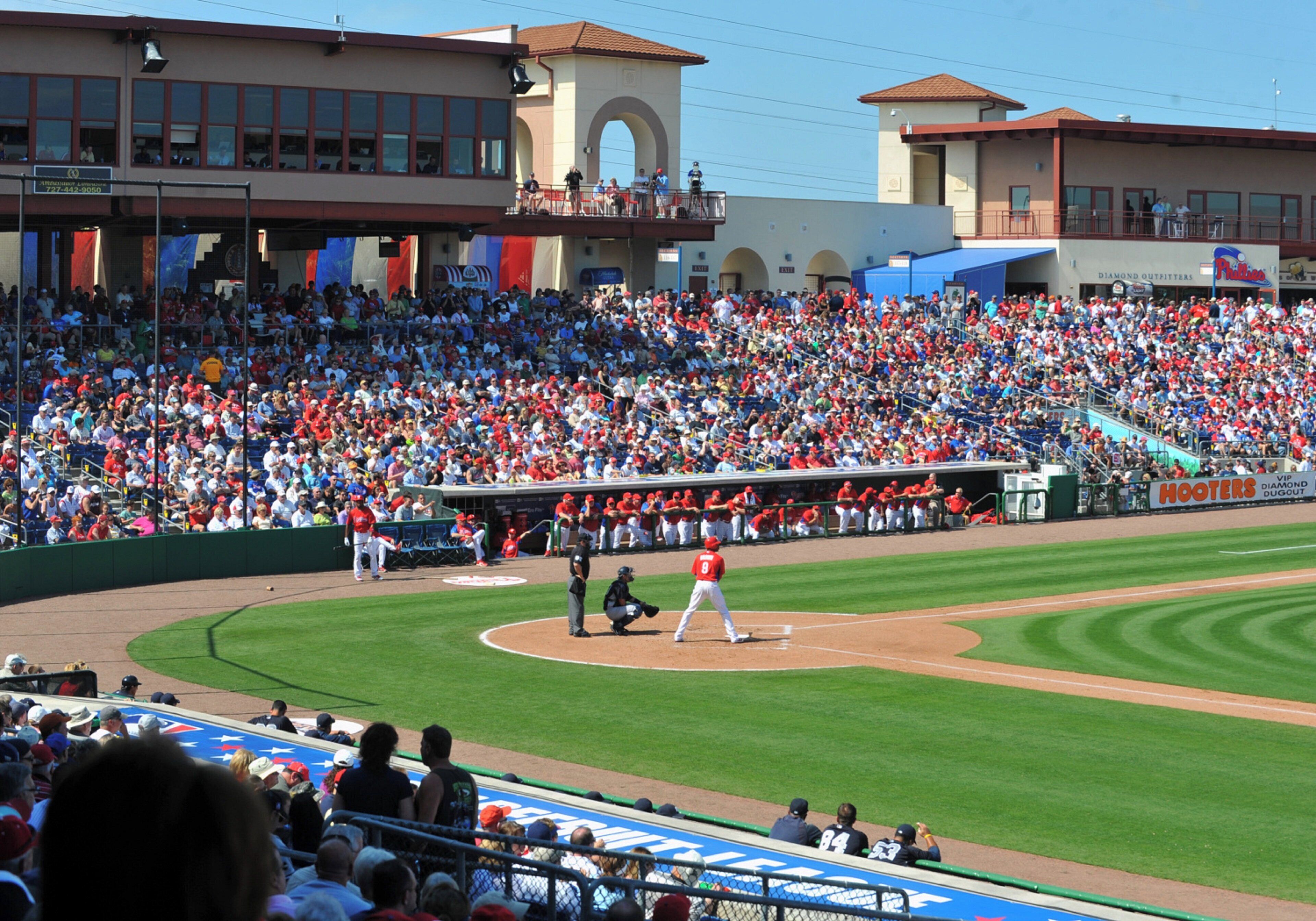 A baseball stadium with a large crowd, a baseball diamond, and a scoreboard.