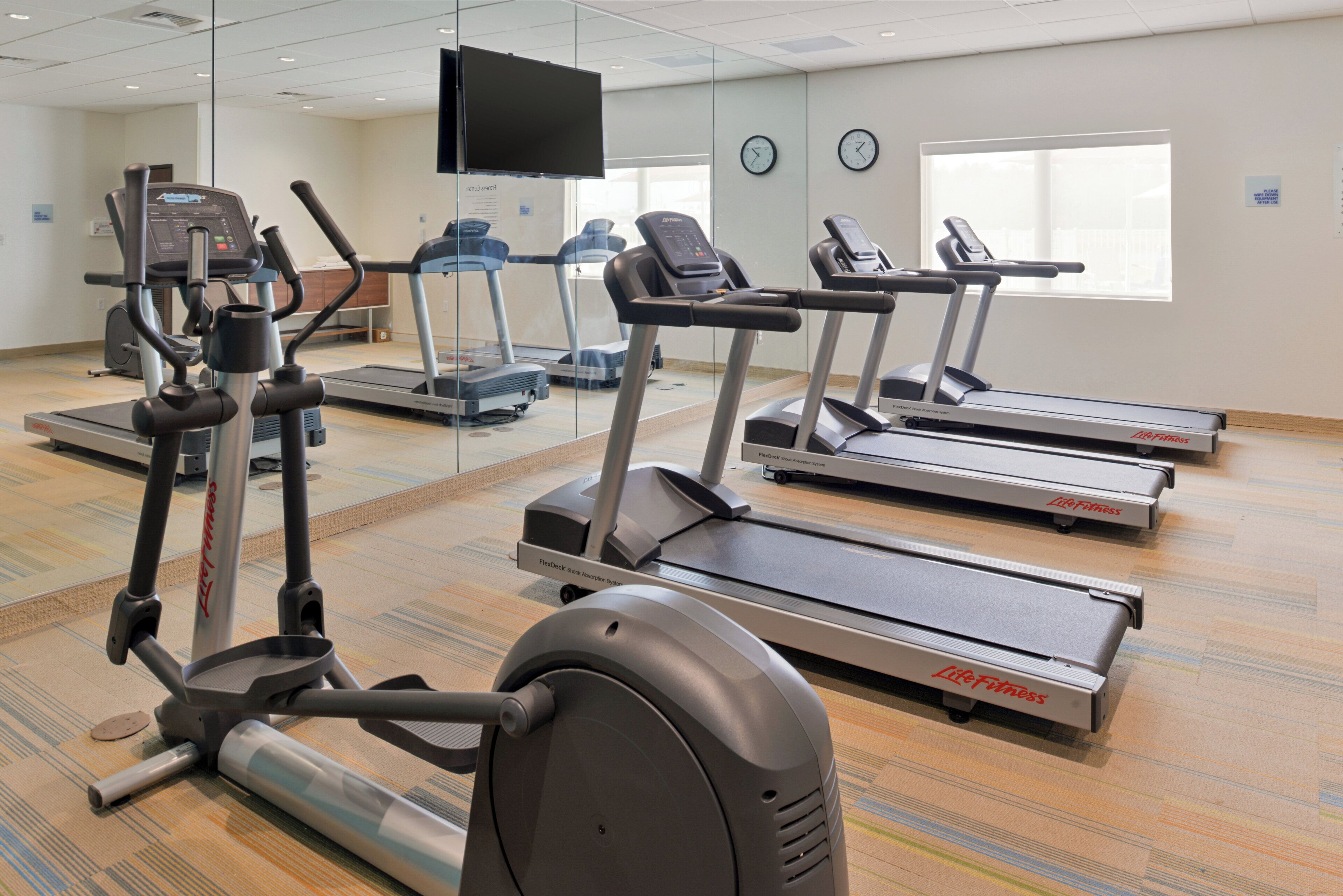 A fitness center with treadmills, ellipticals, and a stationary bike.