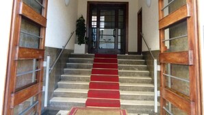 A staircase with a red carpet leading to a door with glass panels. - Amica Rome Guest House (Rome)