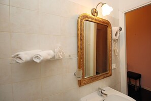 A bathroom with a large mirror, a hairdryer, and a towel rack. - Amica Rome Guest House (Rome)