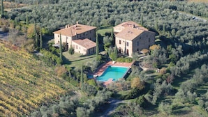 A large stone house with a swimming pool surrounded by dense vegetation. - Rigone in Chianti (Montaione)