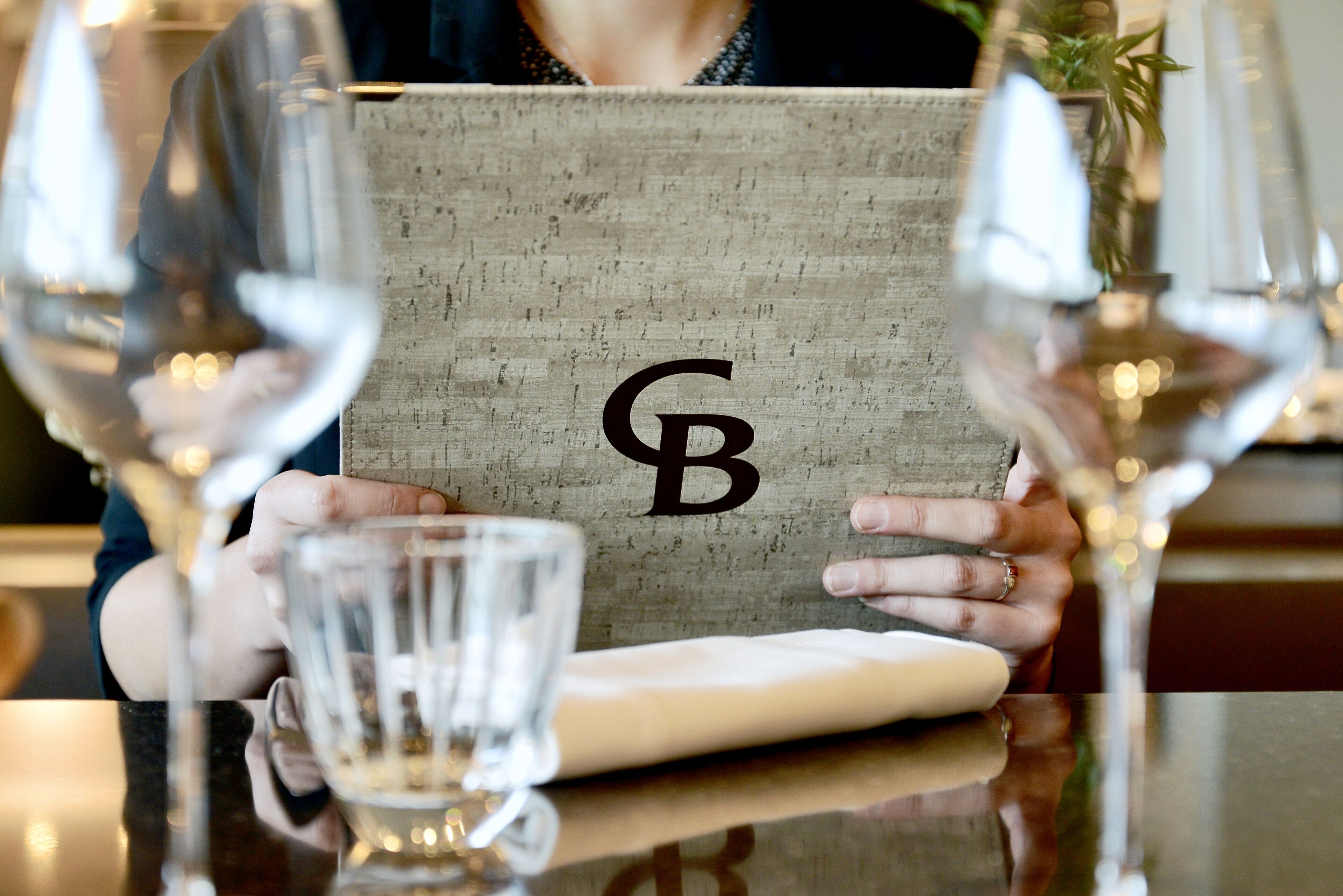 A person holding a textured bag with a monogrammed logo.