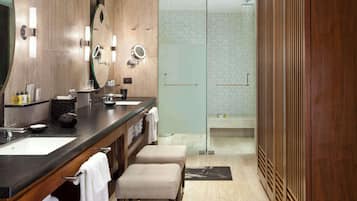 Une salle de bain moderne avec un meuble-lavabo en bois, deux vasques et une cabine de douche en verre.