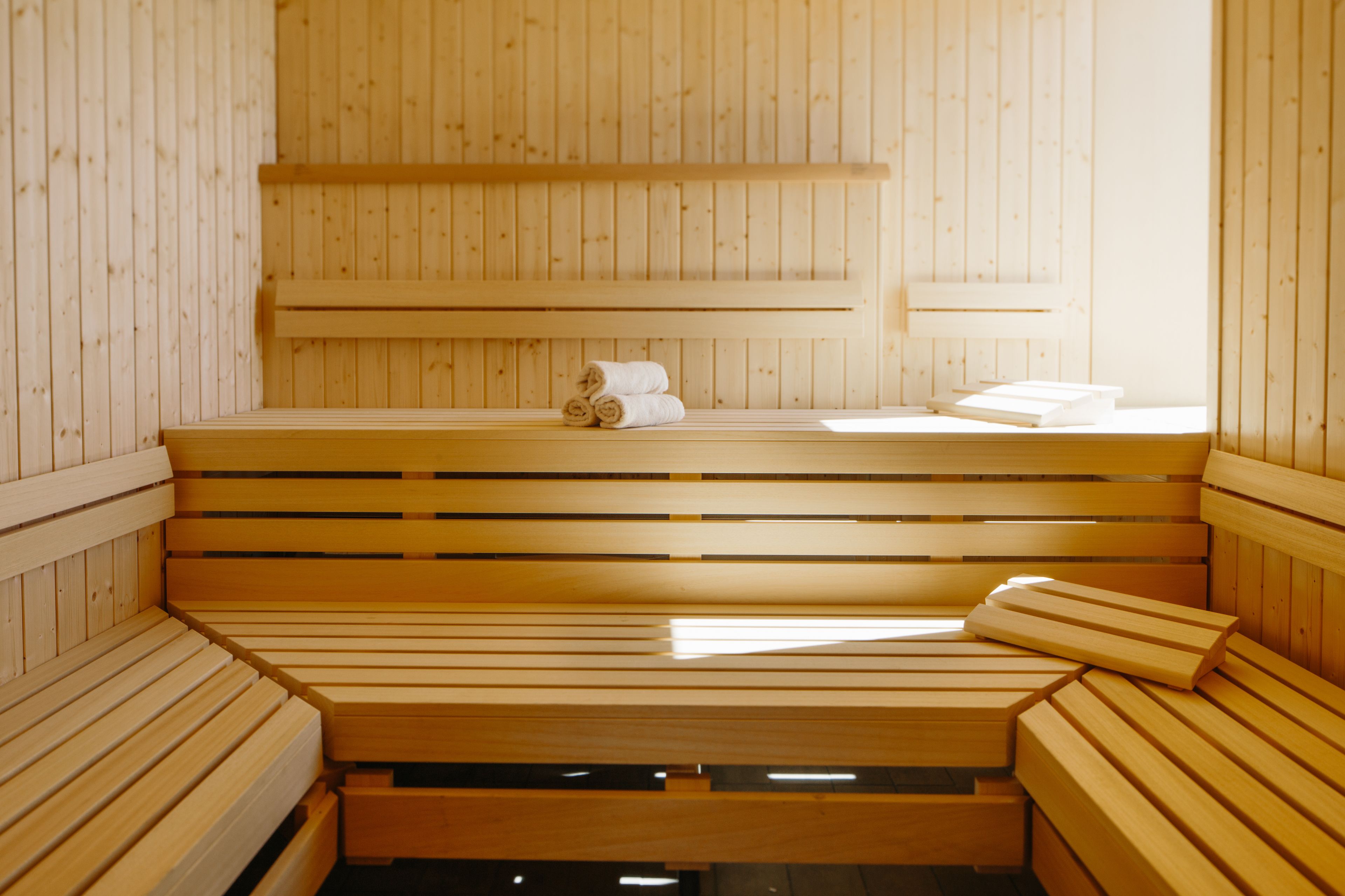 A wooden sauna with benches and a bench seat.