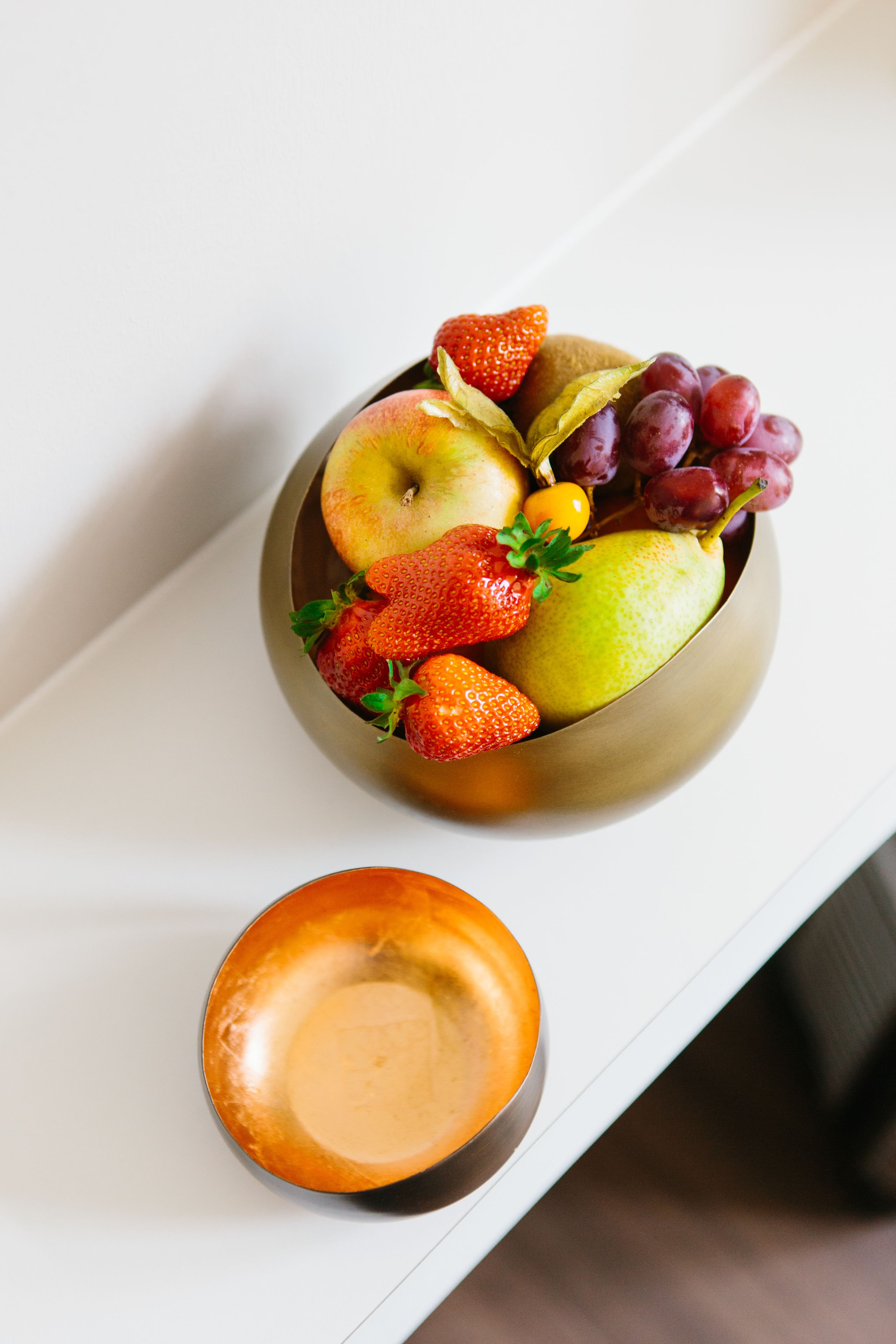 Eine Schale Obst auf einem weißen Tisch.