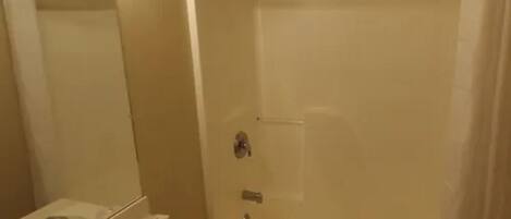 A bathroom with a sink, mirror, and shower.