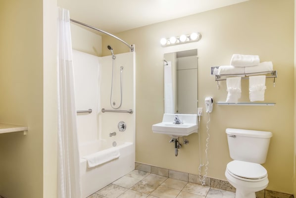 A bathroom with a bathtub, a sink, a toilet, and a mirror with lights. - GuestHouse Montesano (Montesano)