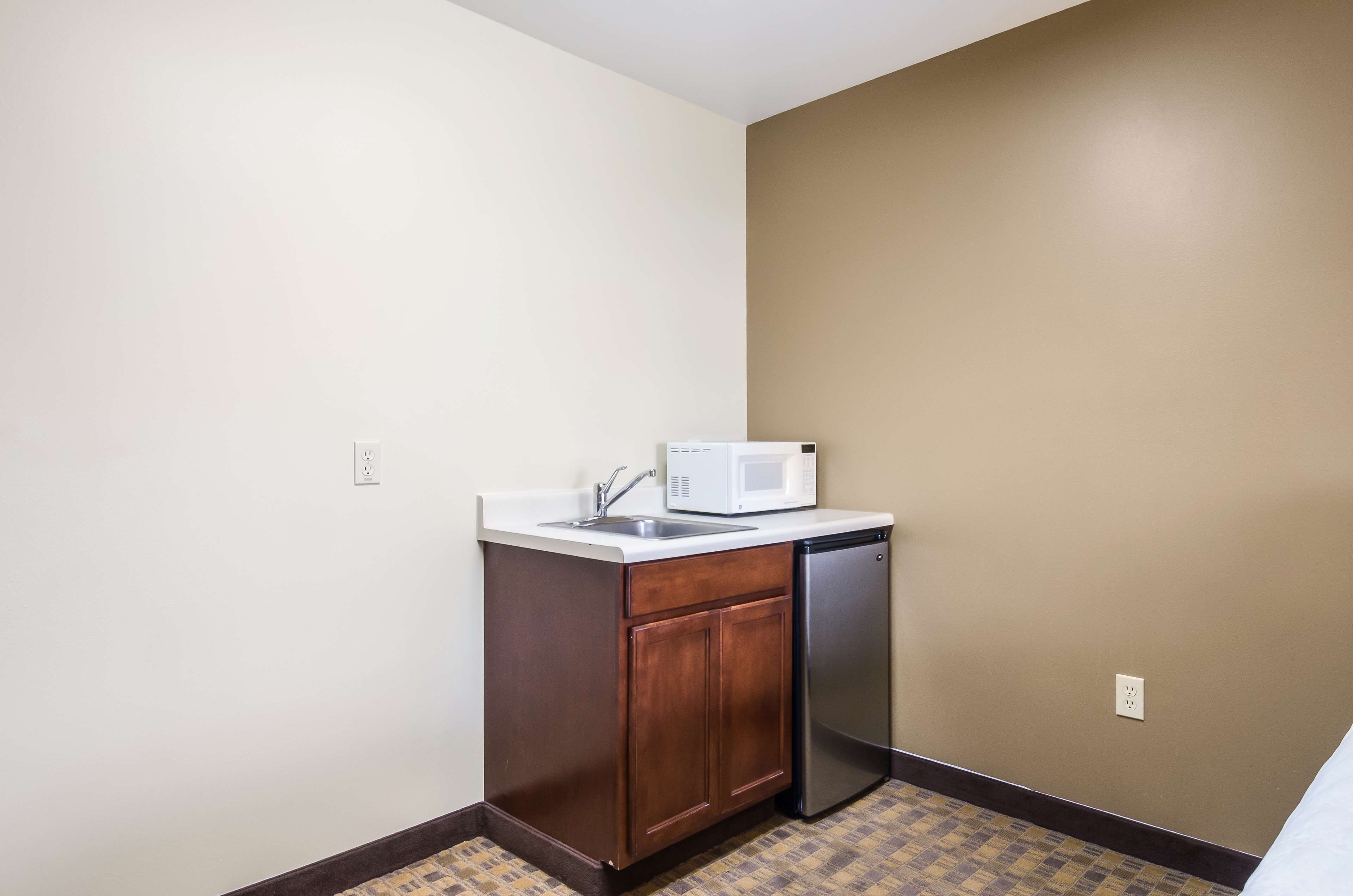 A small kitchenette with a microwave, sink, and dishwasher.