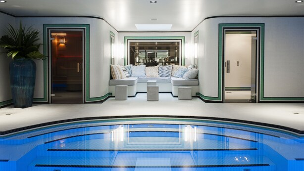 A modern indoor swimming pool with a seating area, a large vase, and a well-lit interior. - Hôtel Eiffel Blomet (Paris)
