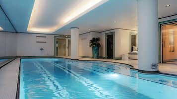Relax by the rectangular pool surrounded by a light-colored tile floor and sleek columns.