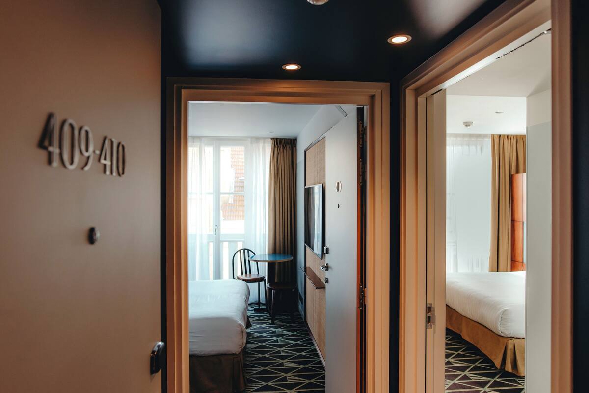 A hotel room with a bed, a desk, and a chair.