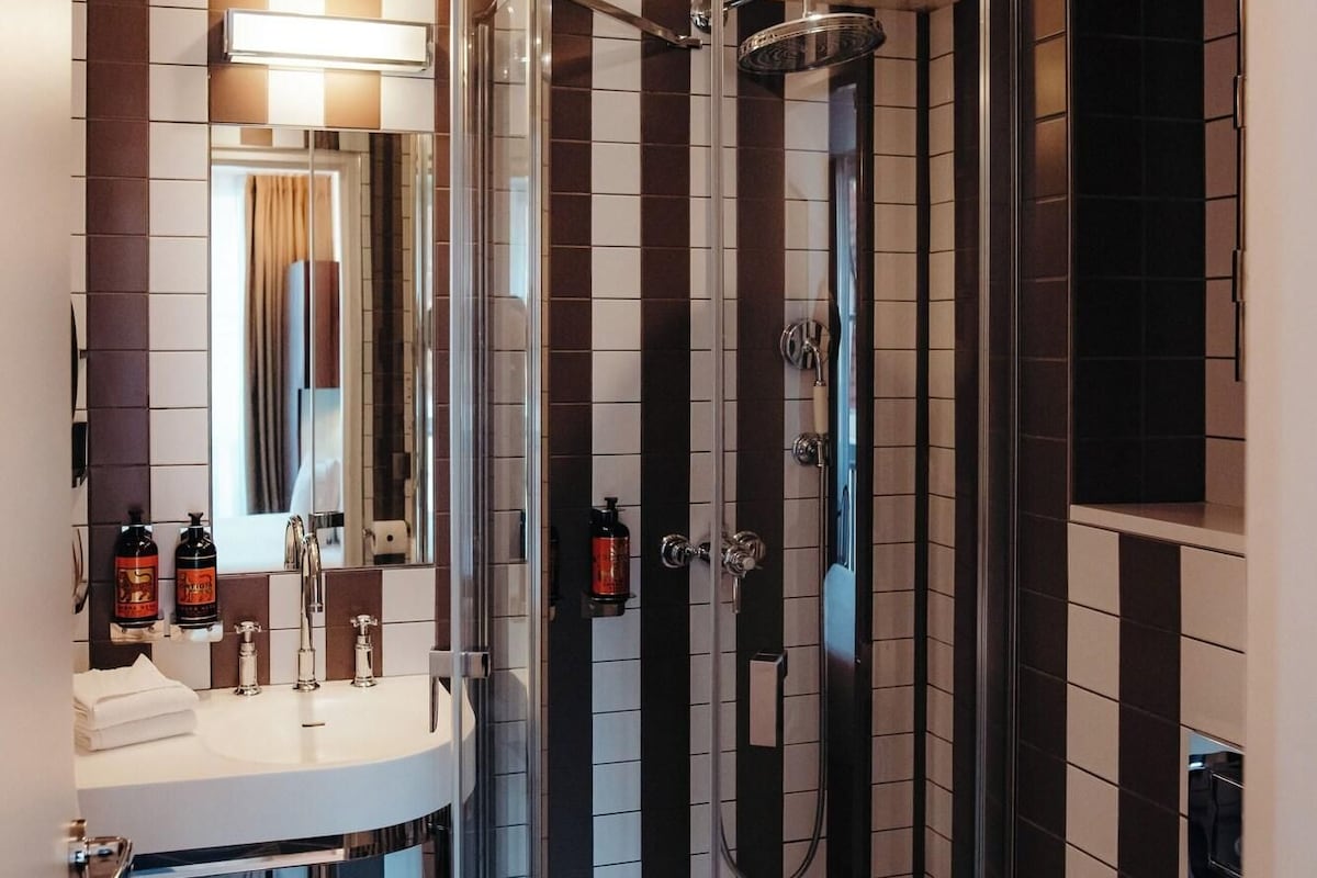 A modern bathroom with a glass-enclosed shower, a vanity with a mirror, and a toilet.