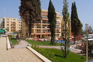 A hotel with a pool area, outdoor seating, and a well-maintained garden. - Hotela Panorama Vigo (Nessebar)