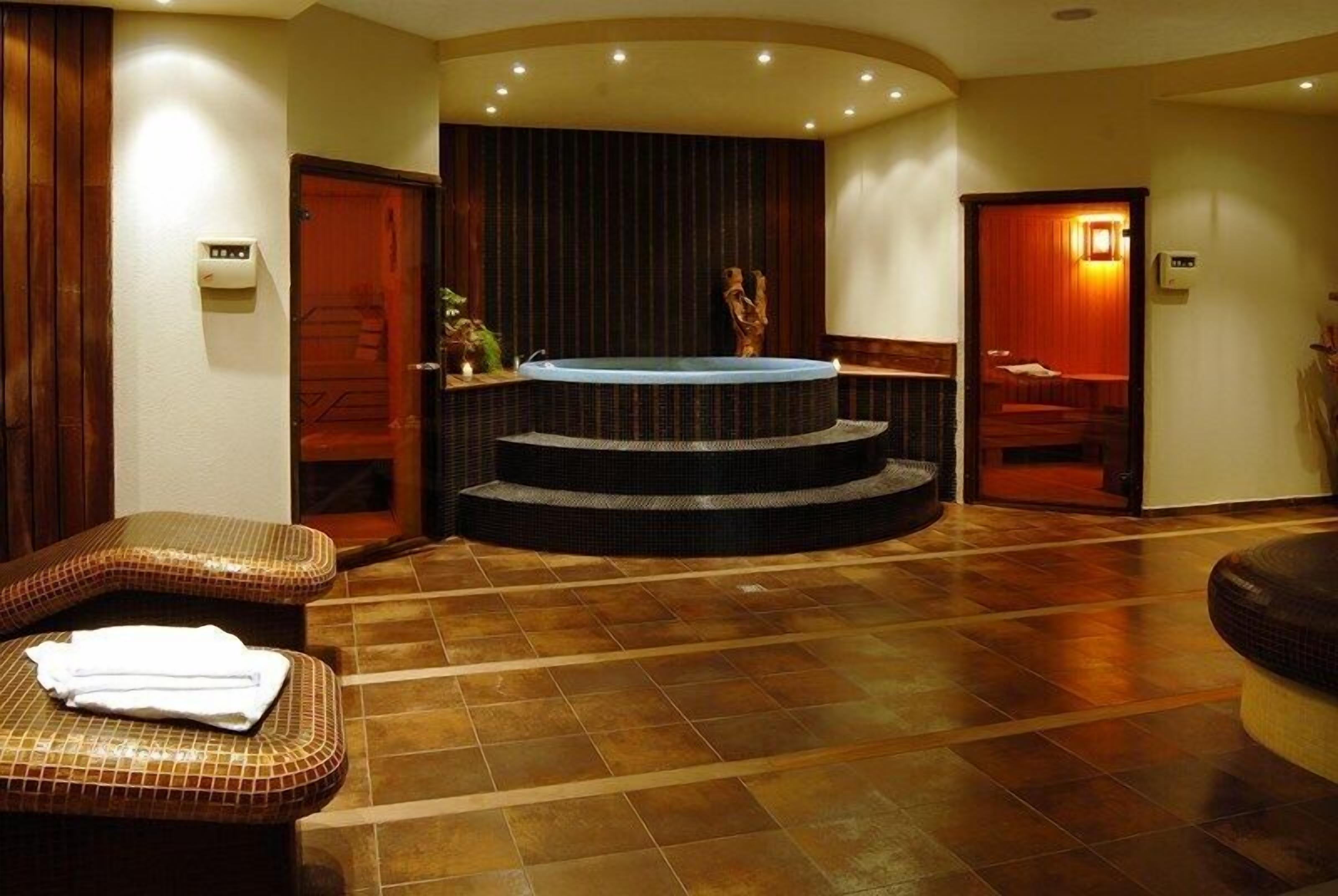 A spa area with a hot tub, seating, and a staircase leading to a second level.