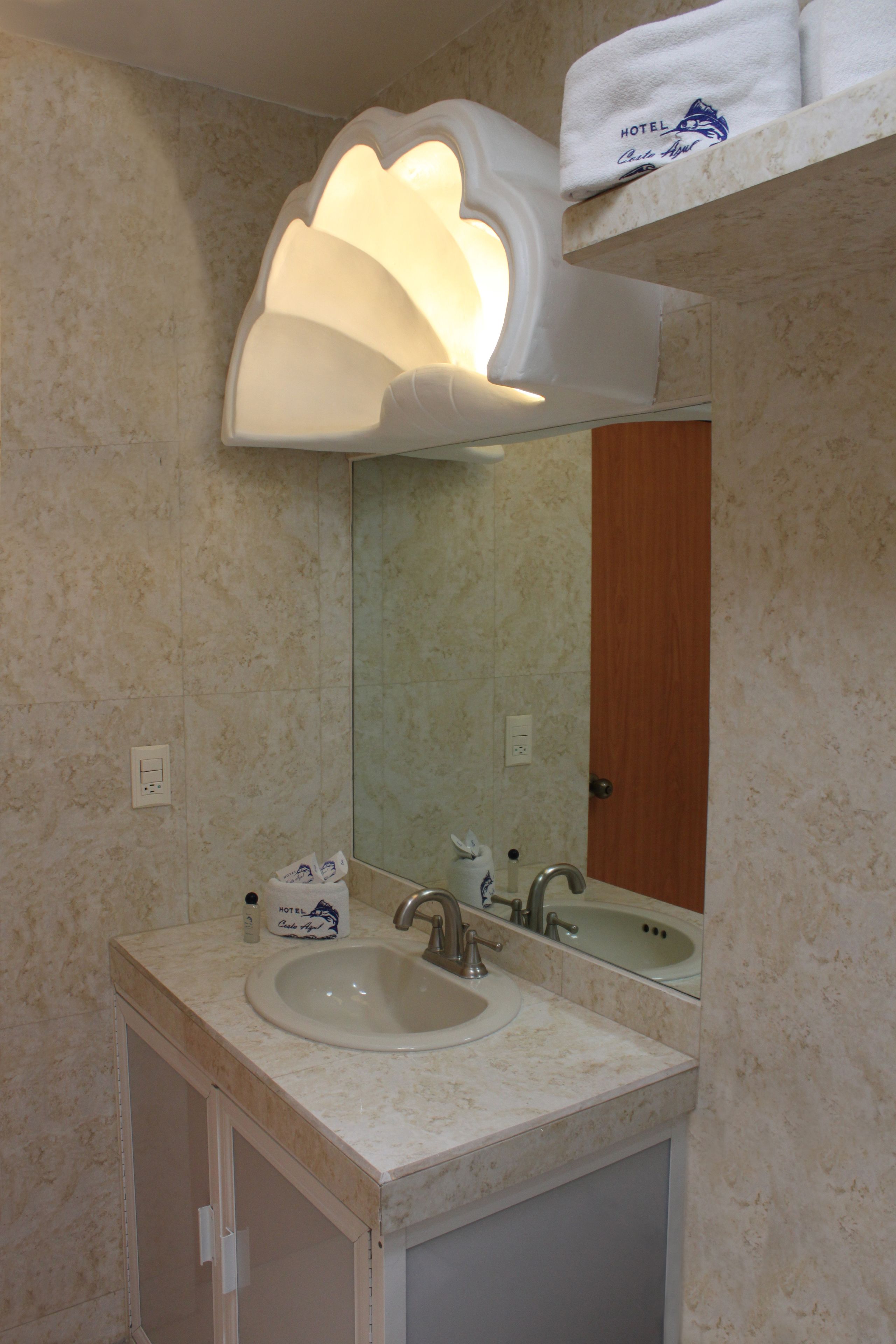 A bathroom with a sink, mirror, and towel rack.