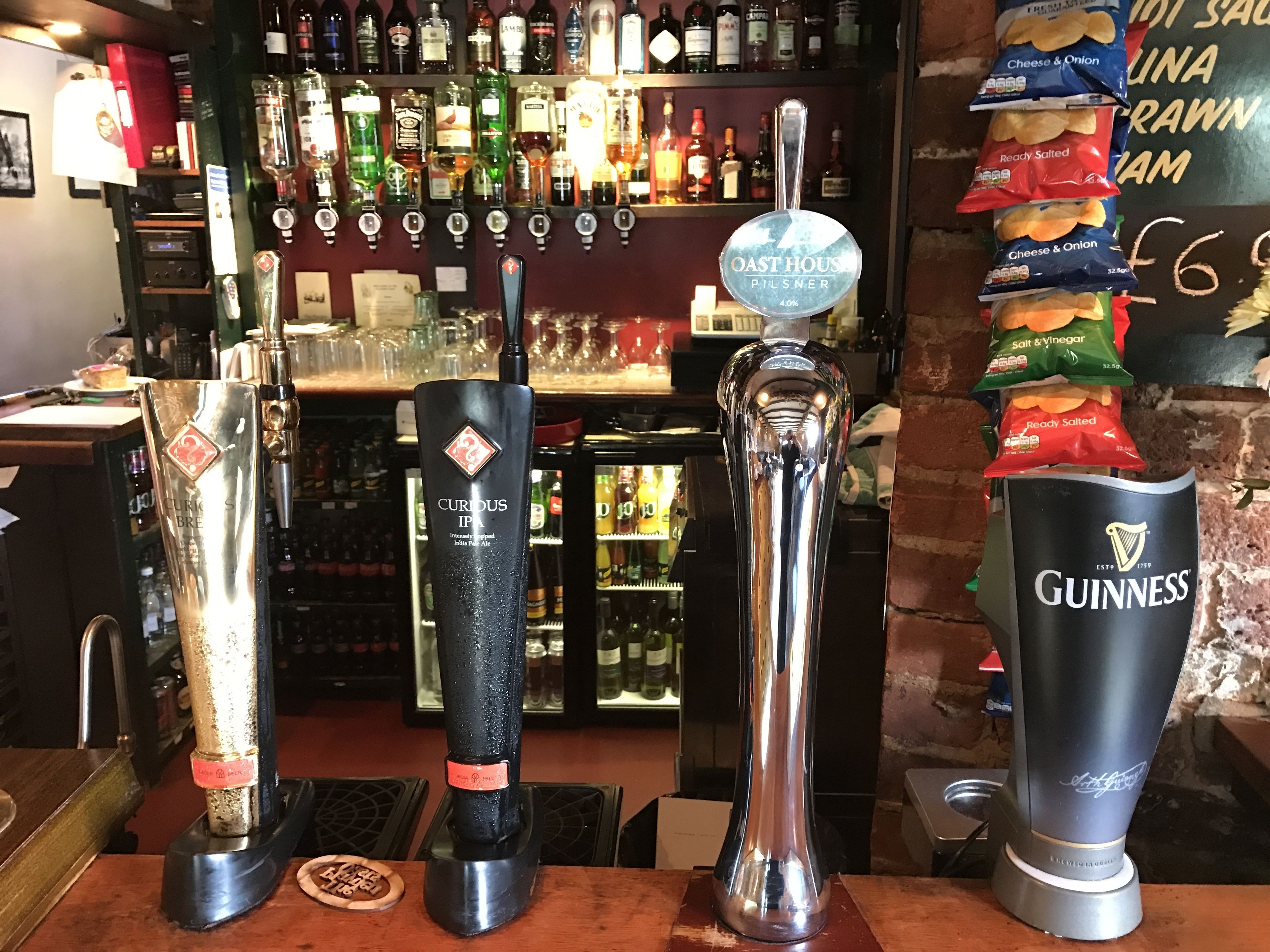 Un espace bar doté de nombreux robinets, proposant des marques comme Curious IPA, Oast House Pilsner et Guinness.