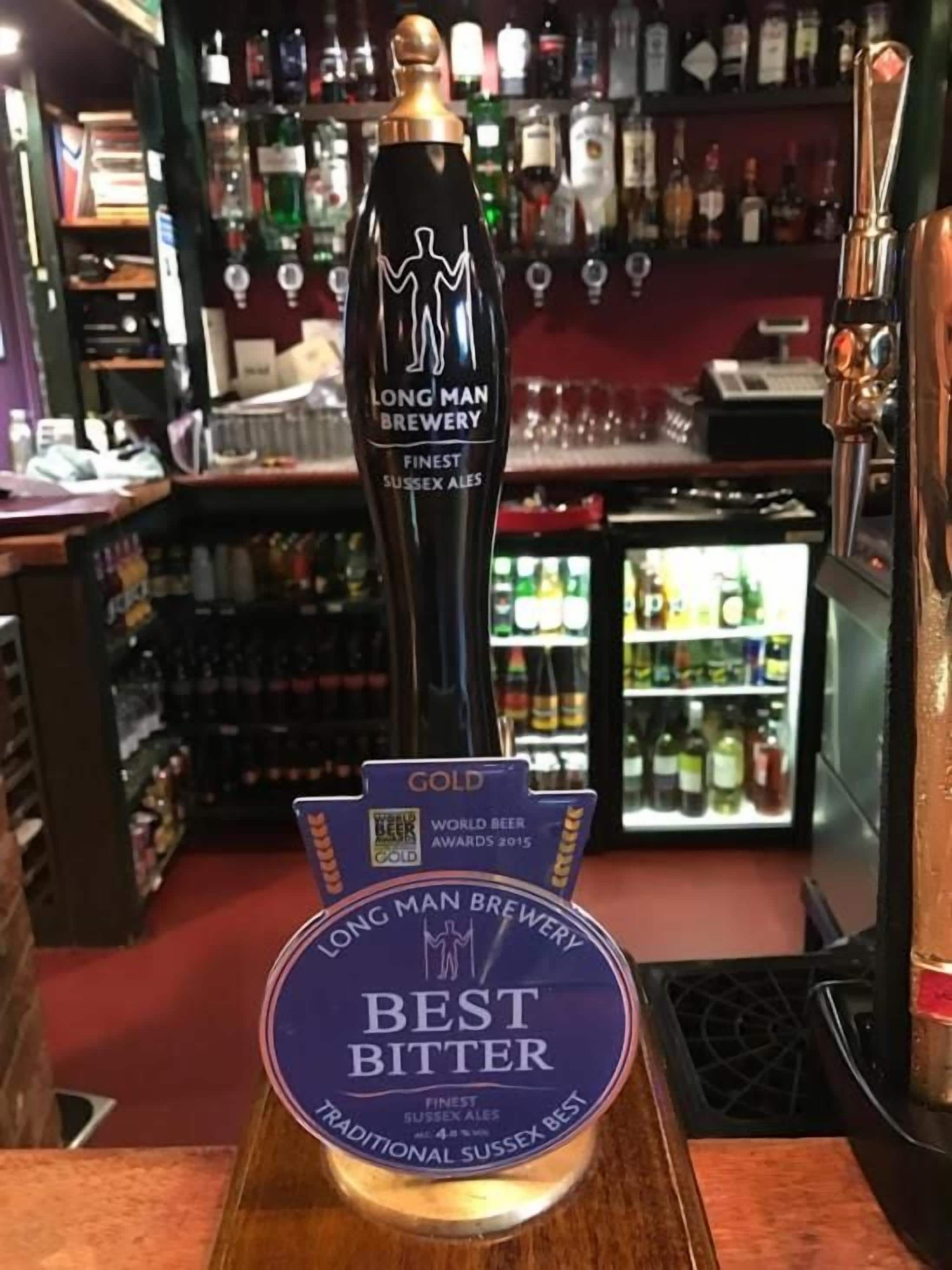 A bar tap labeled 'LONG MAN BREWERY FINEST SUSSEX ALES' with a 'BEST BITTER' award.